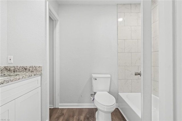 full bathroom with vanity, tiled shower / bath combo, wood-type flooring, and toilet