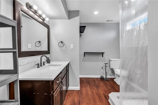 bathroom featuring vanity, hardwood / wood-style floors, and toilet