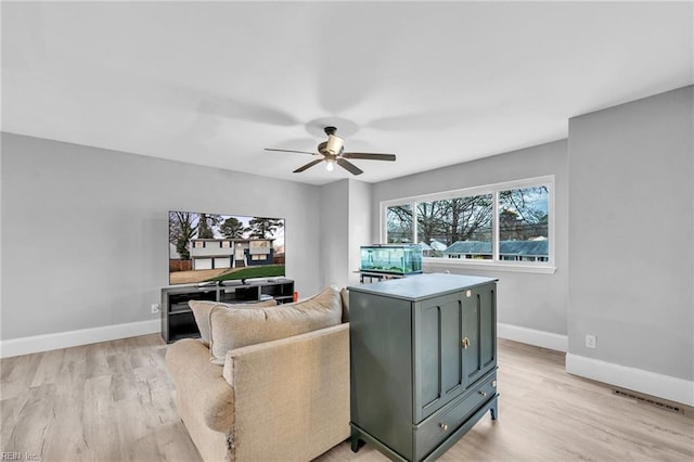 living room featuring ceiling fan and light hardwood / wood-style floors