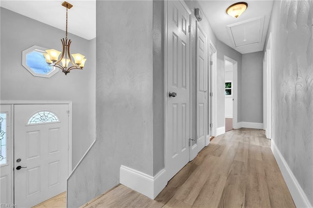 foyer entrance featuring a chandelier and light wood-type flooring