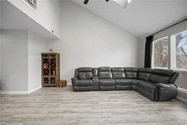 living room with ceiling fan, high vaulted ceiling, and light hardwood / wood-style flooring