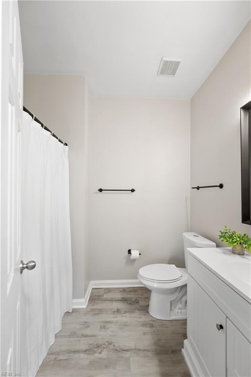 bathroom featuring vanity, hardwood / wood-style floors, and toilet