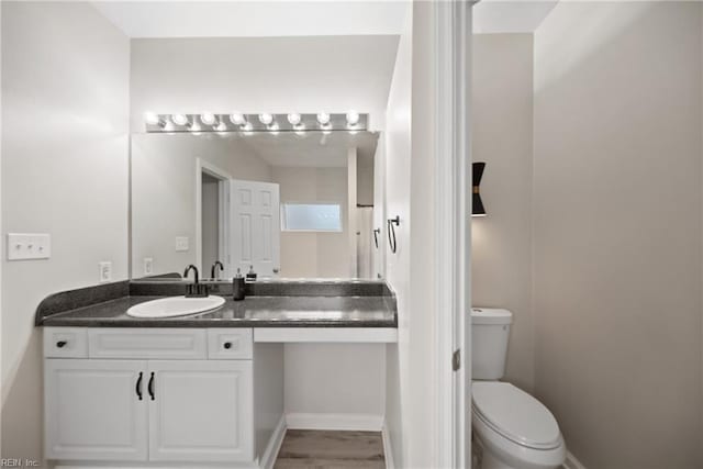 bathroom with hardwood / wood-style flooring, vanity, and toilet