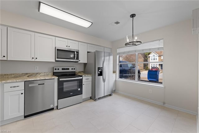 kitchen featuring stainless steel appliances, hanging light fixtures, and white cabinets