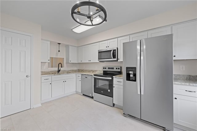 kitchen featuring appliances with stainless steel finishes, decorative light fixtures, white cabinetry, sink, and a chandelier