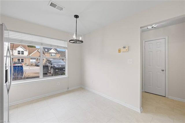 unfurnished dining area featuring a notable chandelier