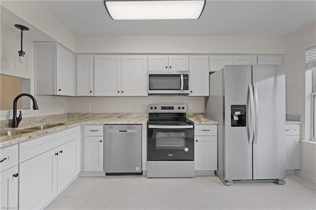 kitchen featuring stainless steel appliances, white cabinetry, hanging light fixtures, and sink