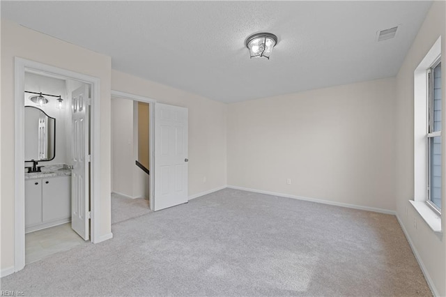 unfurnished bedroom featuring light colored carpet and sink