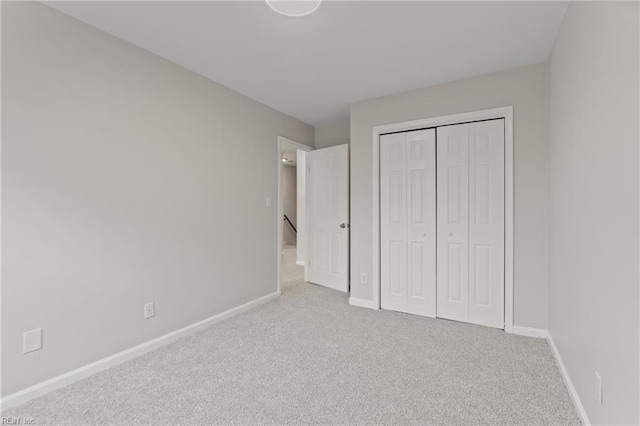 unfurnished bedroom featuring light carpet and a closet