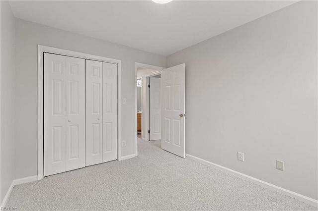 unfurnished bedroom with light colored carpet and a closet