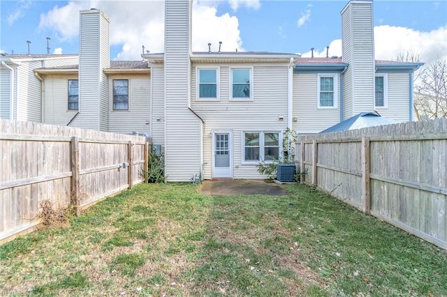 rear view of house with a yard and central AC