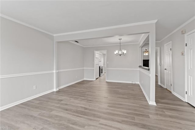 unfurnished room featuring an inviting chandelier, crown molding, and wood-type flooring