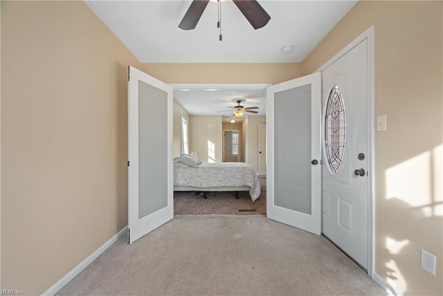 carpeted entryway with french doors and ceiling fan