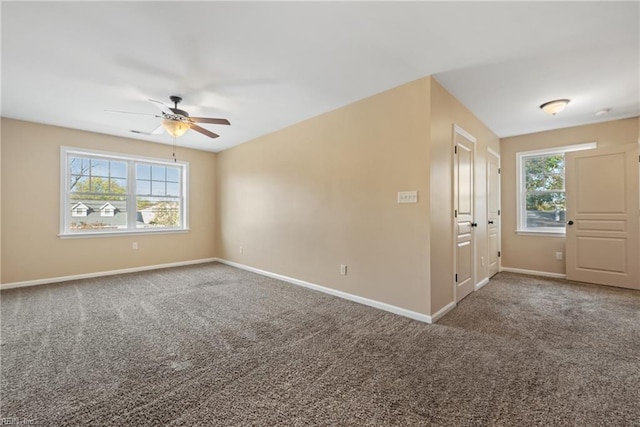 unfurnished room featuring plenty of natural light, carpet floors, and ceiling fan