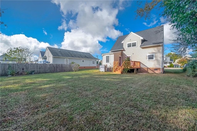 rear view of property with a wooden deck and a lawn