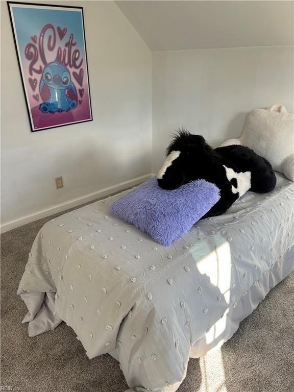 bedroom featuring lofted ceiling and carpet floors