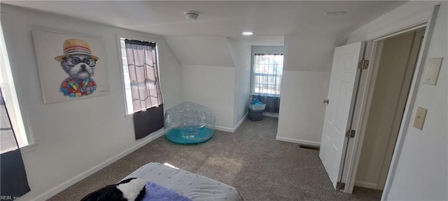 interior space featuring vaulted ceiling, carpet, and baseboards