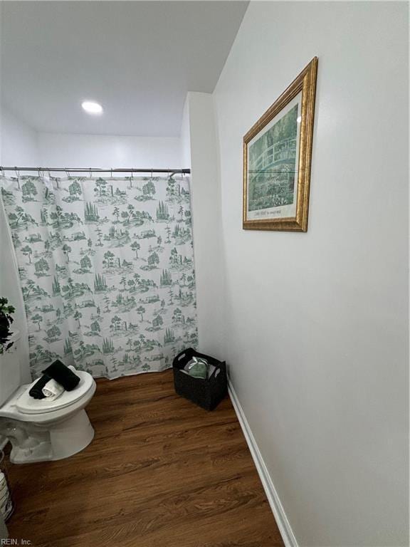 bathroom with hardwood / wood-style floors and toilet