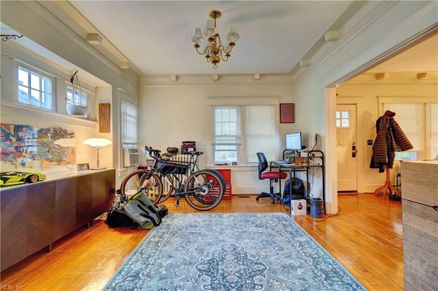 miscellaneous room with wood-type flooring, ornamental molding, and a chandelier