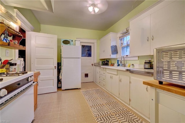 kitchen featuring sink, white appliances, and white cabinets