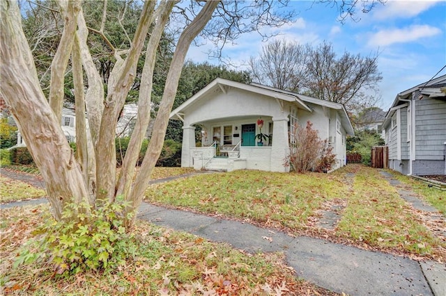 view of front of house with a front yard and a porch