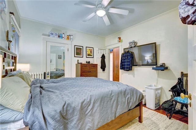 bedroom featuring crown molding, ceiling fan, radiator heating unit, and hardwood / wood-style floors