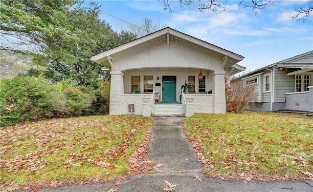 bungalow-style house with covered porch and a front lawn