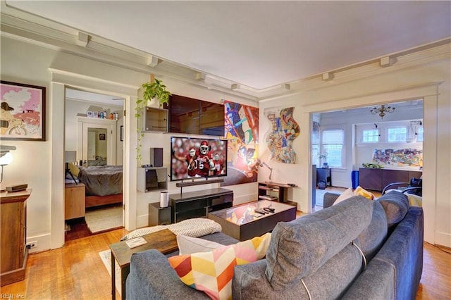 living room with crown molding and light hardwood / wood-style floors