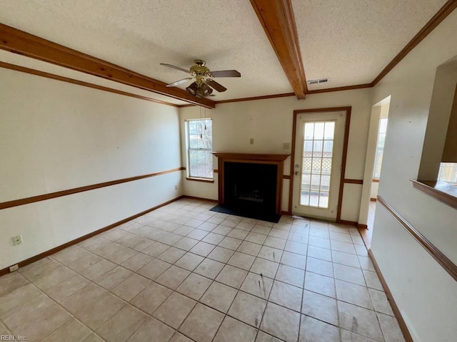 unfurnished living room featuring a healthy amount of sunlight, beam ceiling, a textured ceiling, and light tile patterned floors