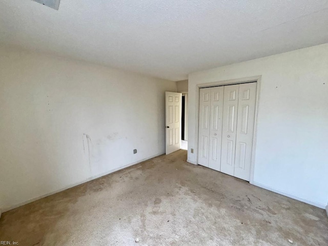 unfurnished bedroom featuring light carpet and a closet