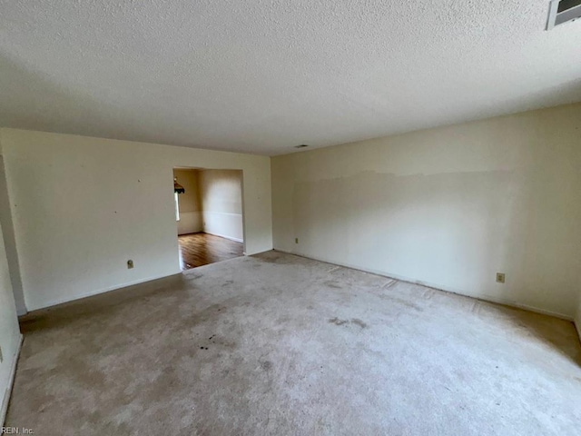 spare room featuring carpet and a textured ceiling