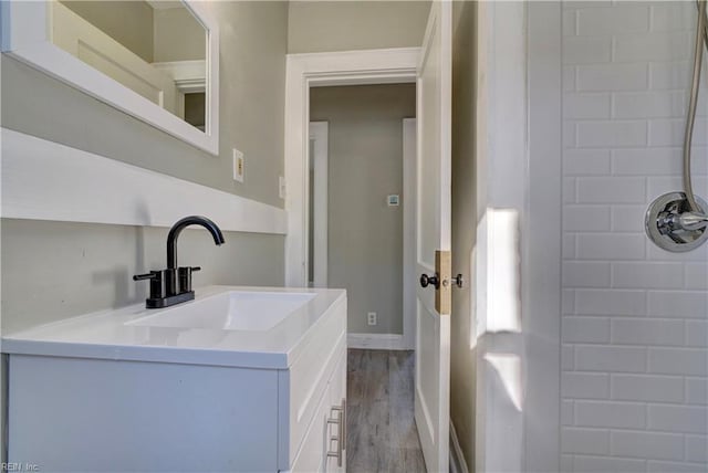 bathroom with vanity, hardwood / wood-style flooring, and a shower