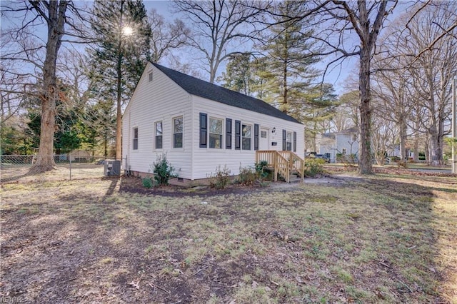 view of property exterior with cooling unit and a yard