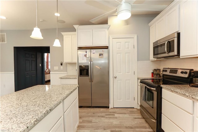 kitchen featuring white cabinetry, light stone counters, decorative light fixtures, and stainless steel appliances