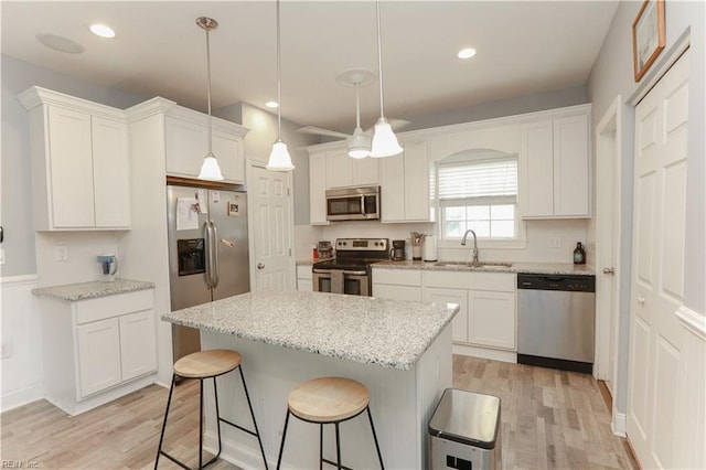 kitchen featuring pendant lighting, sink, white cabinetry, and appliances with stainless steel finishes