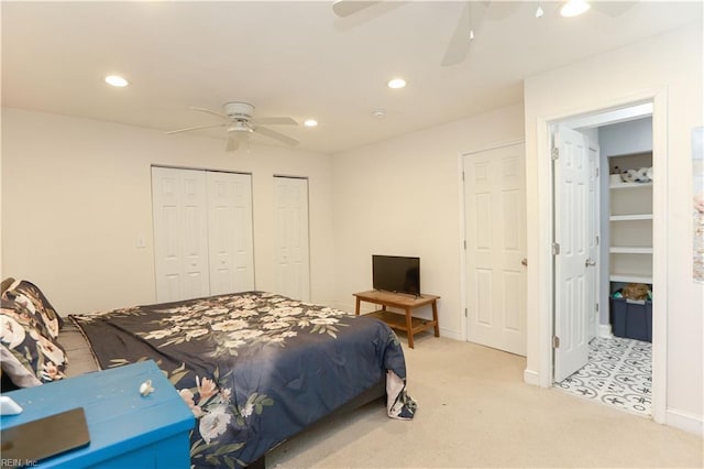 carpeted bedroom with multiple closets and ceiling fan