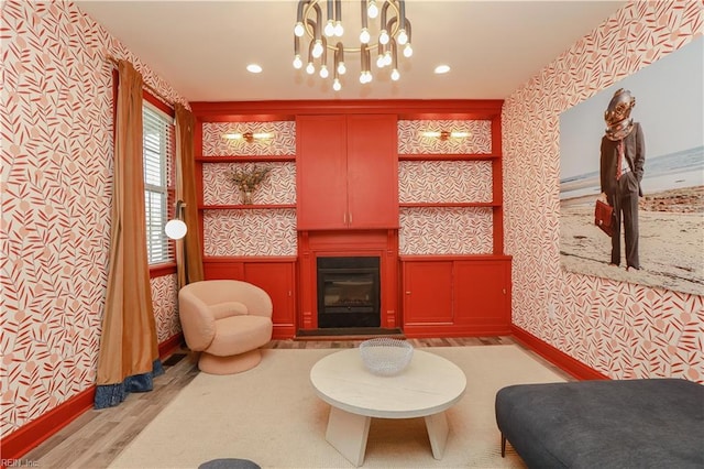 living area featuring an inviting chandelier and light hardwood / wood-style flooring