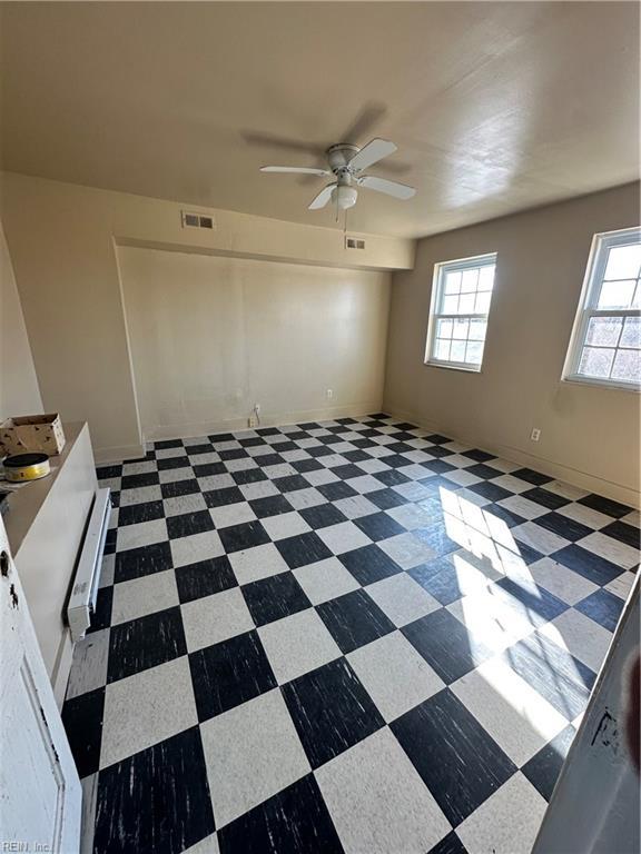 unfurnished room with ceiling fan and a wealth of natural light