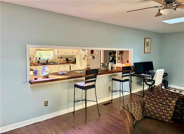 interior space featuring white cabinetry, white refrigerator, ceiling fan, kitchen peninsula, and dark wood-type flooring