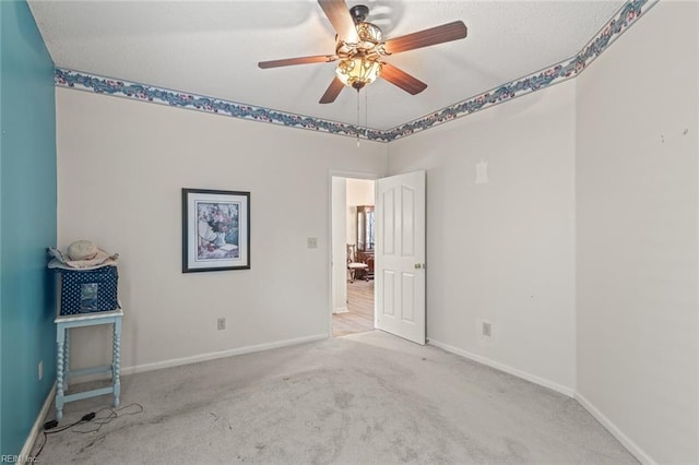 carpeted spare room featuring ceiling fan