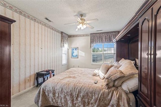 carpeted bedroom with ceiling fan and a textured ceiling