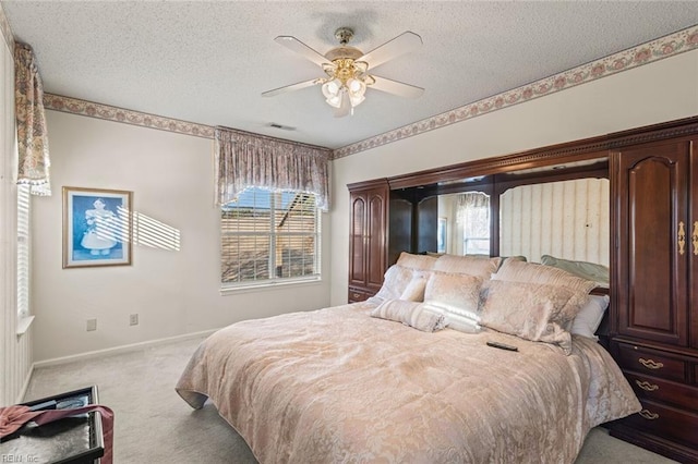 carpeted bedroom with ceiling fan and a textured ceiling