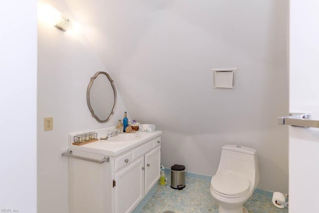 bathroom featuring lofted ceiling, vanity, and toilet