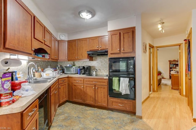 kitchen featuring sink, decorative backsplash, and black appliances