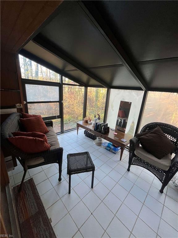 sunroom / solarium featuring lofted ceiling with beams