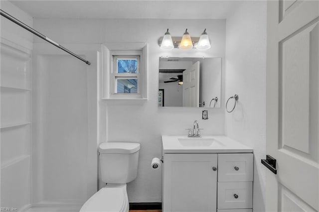 bathroom with vanity, ceiling fan, a shower, and toilet