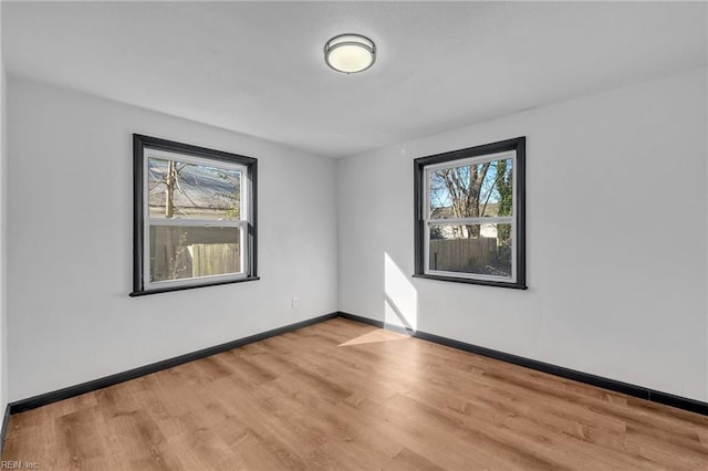 spare room with plenty of natural light and light wood-type flooring