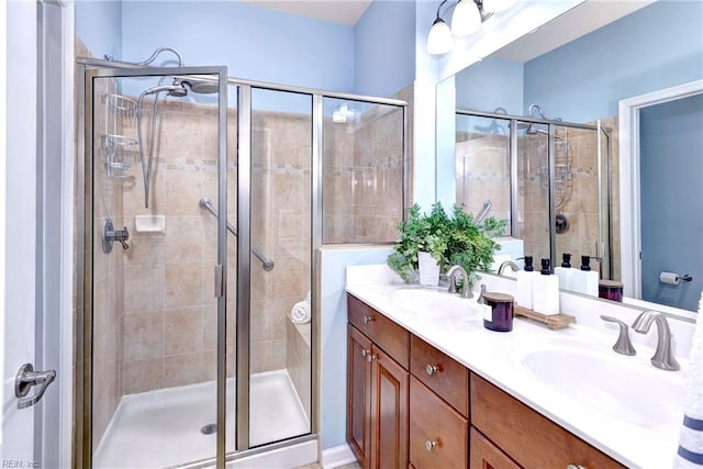 bathroom featuring a shower with door and vanity