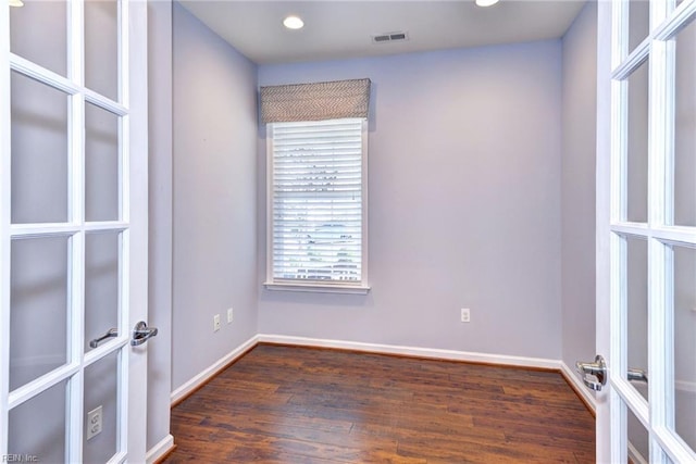 unfurnished room featuring dark hardwood / wood-style floors and french doors