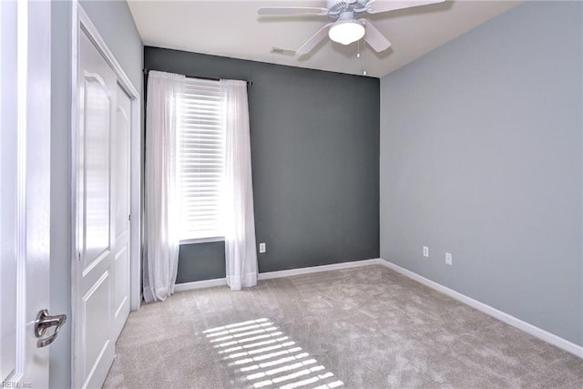 carpeted spare room with ceiling fan